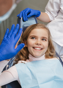 Child smiling and giving dentist a high five