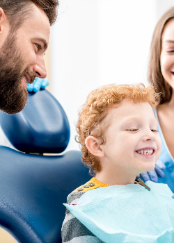 Child smiling in mirror after getting metal-free filling