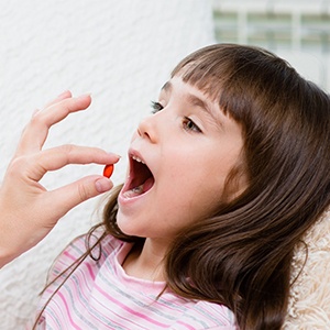a child taking a pill before a dental appointment