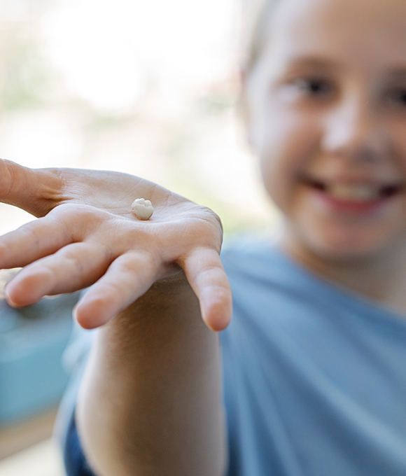 Child holding their lost tooth
